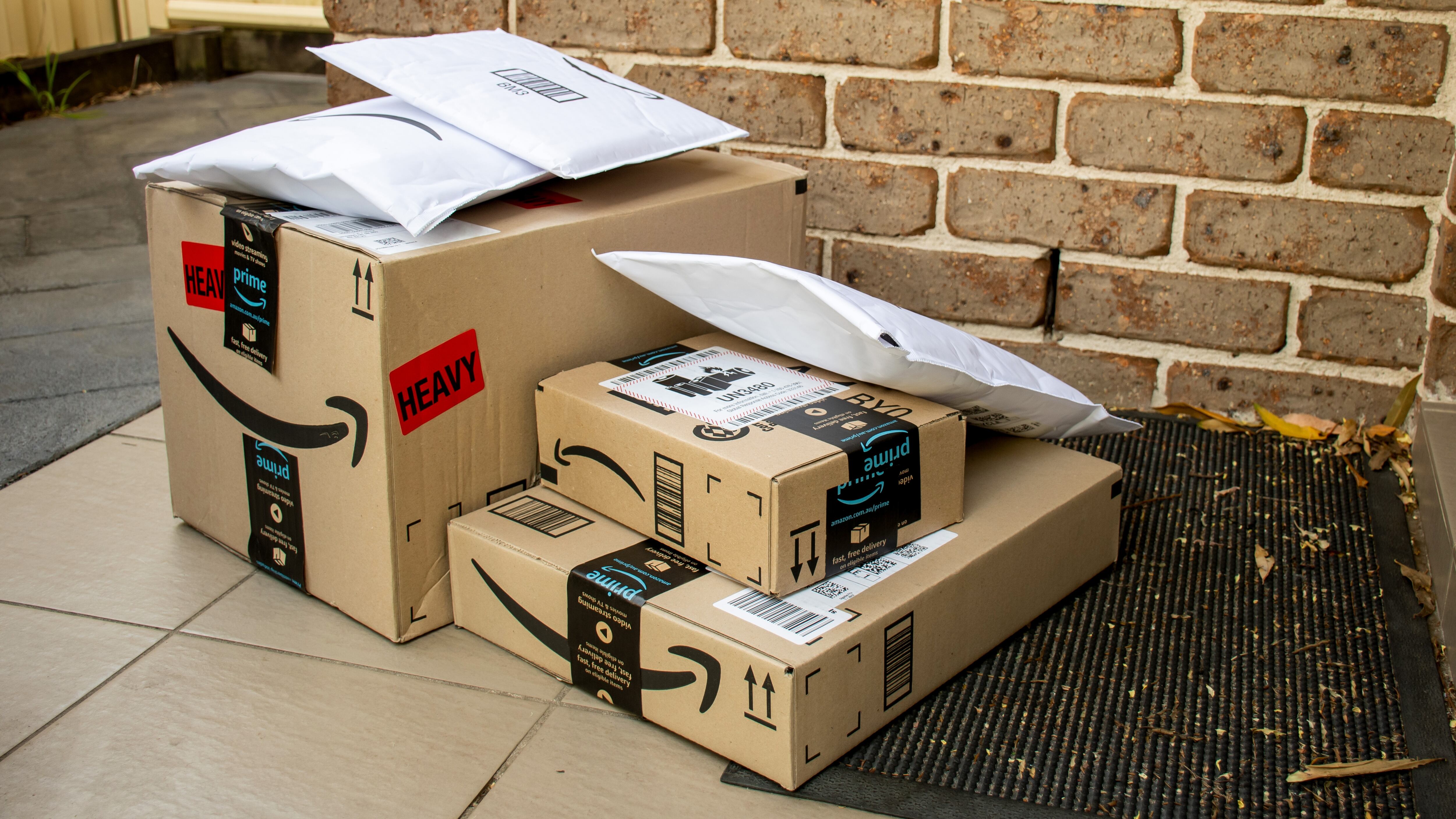 Amazon prime boxes and envelopes delivered to a front door of residential building
