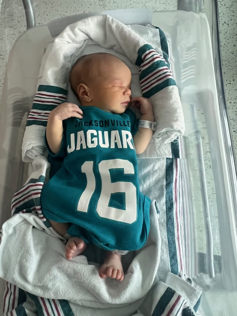 Babies from various local Baptist Health hospitals wearing Trevor Lawrence jersey onesies