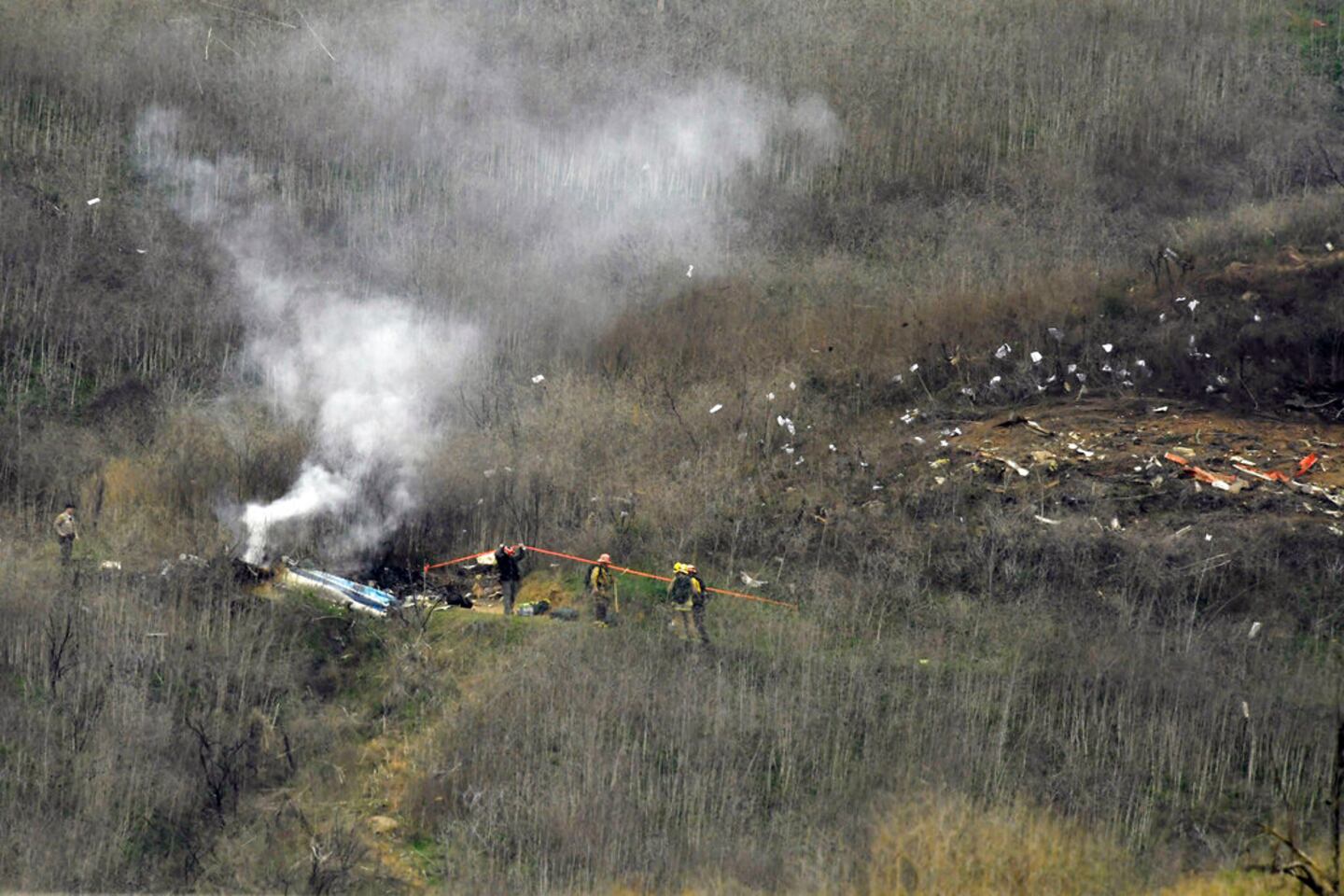 FILE - In this Jan. 26, 2020, file photo, firefighters work the scene of a helicopter crash that killed nine people, including Kobe Bryant and his daughter, Gianna, in Calabasas, Calif. Bryant's widow, Vanessa Bryant, on Wednesday, March 17, 2021, posted the names of four Los Angeles County sheriff's deputies she alleges took and shared graphic photos from the site of the helicopter crash. (AP Photo/Mark J. Terrill, File)